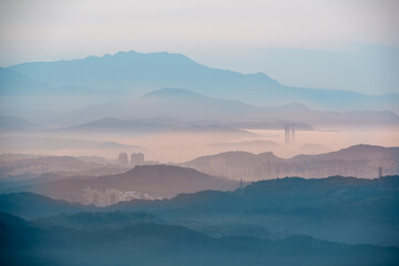 Clouds are among the mountains. There are tall buildings in the valley. Jiufen is an old mountain...
