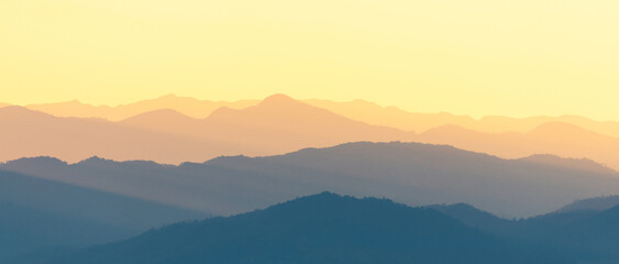 Panoramic scene of bright sunlight over the layers of mountain range.