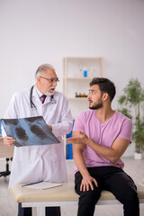 Fototapeta premium Young male patient visiting old male doctor radiologist