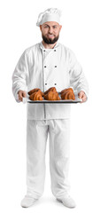 Male baker with tray of tasty croissants on white background