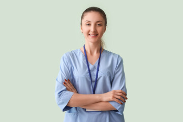Female medical intern with badge on green background