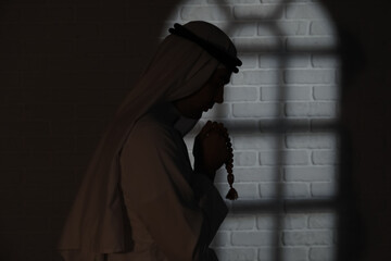 Naklejka premium Praying Muslim man in dark room