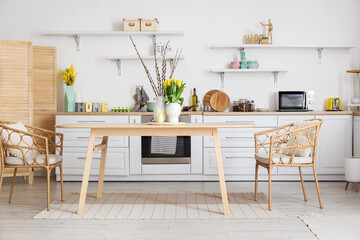 Interior of kitchen with Easter decor, white counters and dining table