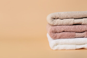Fototapeta na wymiar Stack of clean folded towels on color background