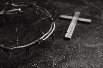 Fototapeta na wymiar Crown of thorns and cross on dark background, closeup