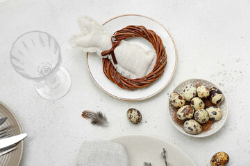Fototapeta na wymiar Table setting with Easter eggs, bunny and feathers on white background