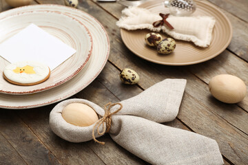 Table setting with Easter eggs on wooden background