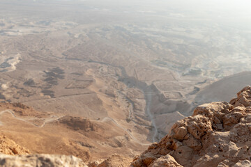 View  before sunrise from the ruins of the fortress wall of the fortress of Masada to the remains of a Roman battle camp and the adjacent valley, in southern Israel