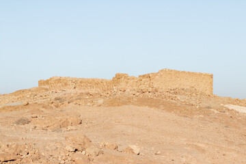 The remains  of internal buildings in the rays of the rising sun in the ruins of the fortress of Masada - is a fortress built by Herod the Great on a cliff-top off the coast of the Dead Sea, Israel