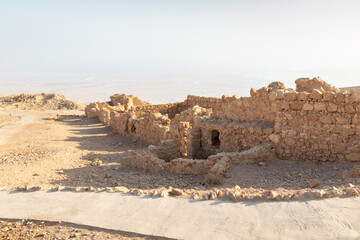 The remains  of internal buildings in the rays of the rising sun in the ruins of the fortress of Masada - is a fortress built by Herod the Great on a cliff-top off the coast of the Dead Sea, Israel