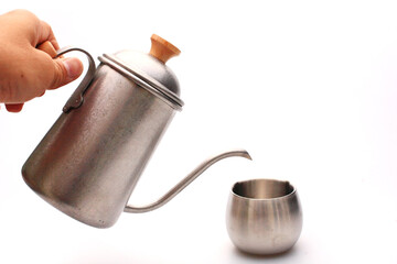 hold vintage coffee kettle pour to metal cup on white background