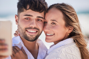 Selfie, love and couple on a date at the beach for valentines day, romance or anniversary in summer. Happiness, smile and young man and woman hugging while taking picture by the ocean on vacation.