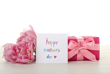 Greeting card with text HAPPY MOTHER'S DAY, tulips and gift on table against white background