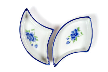 Triangular plates on a white background. Dishes of the original shape with a blue floral pattern.