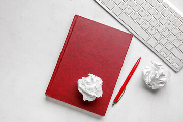 Book, crumpled paper balls, pen and keyboard on light background. World Poetry Day celebration