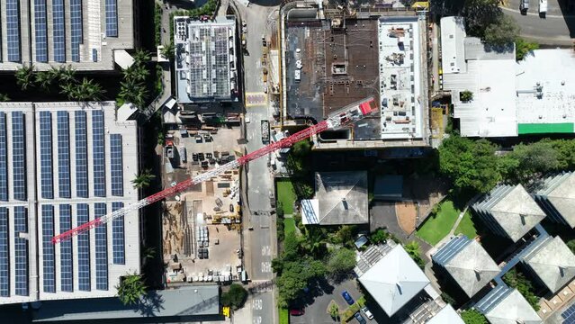 Top-down drone shot of a construction crane in action. Witness the precision and power as it spins to pick up materials. Perfect for construction and urban development projects.