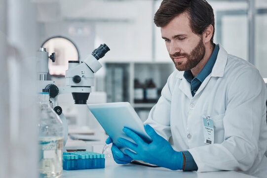 Science, Medical Research And Man With Tablet In Laboratory Checking Results, Internet Or Email Online. Healthcare, Medicine And Innovation In Vaccine Manufacturing, Scientist Reading Journal Website