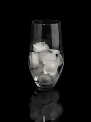 Glass with ice on a black background. Close-up.
