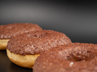 Chocolate donut with chocolate chips on a black background. close-up.
