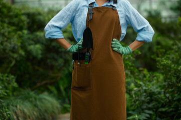 Closeup female gardener in overalls with garden tool in pocket