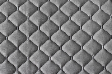 Fototapeta premium Quilted fabric pattern. The texture of the sofa is gray eco leather. Decorative background.
