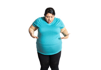 Sad overweight indian woman looking belly fat with surprised expression on her face standing isolated over white background. copy space. obesity and Loose weight concept. - obrazy, fototapety, plakaty