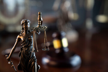 Law and justice concept. War crimes. Gavel and Themis sculpture in lawyers office. Gray bokeh...