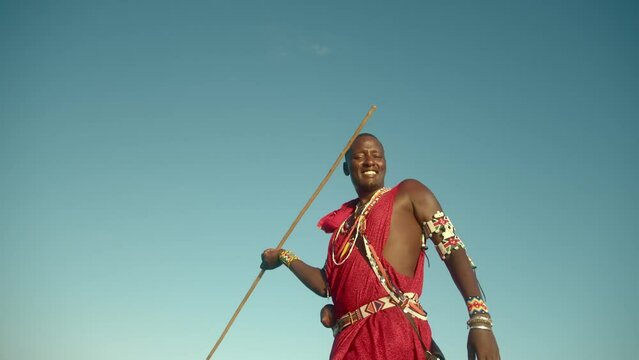 African Maasai Warrior Man Hunter Wearing Traditional Dress In The Masai Mara, Kenya. Medium Shot