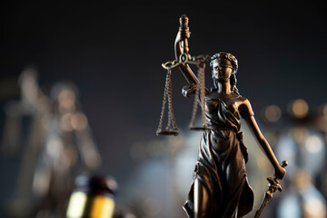 Law and justice concept. War crimes. Gavel and Themis sculpture in lawyers office. Gray bokeh...