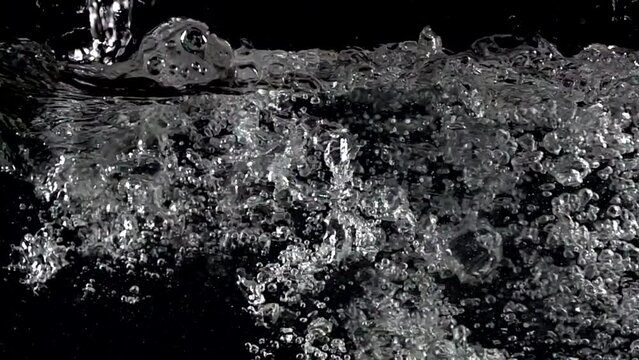 Super slow-motion shot of water splash against black. Shooted with high speed cinema camera at 1000fps
