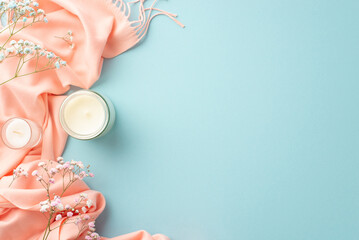 Hello spring concept. Top view photo of candles in glasses gypsophila flowers and pink soft scarf on isolated pastel blue background with copyspace