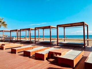 Sunbeds loungers at ocean resort, sea view in distance