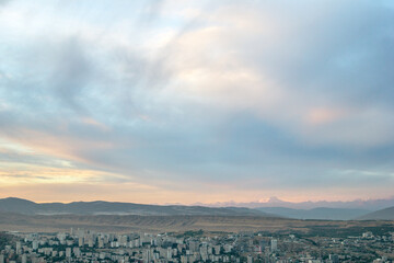 Fototapeta premium Scenic view on Tbilisi city cityscape at twilight with beautiful sunset over the hills.