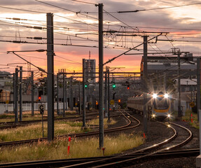 Trains running through Roma Street Station in the dusk in Brisbane - obrazy, fototapety, plakaty