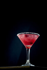 Alcoholic pink cocktail with cranberry and ice in a glass. Concrete background. Vermouth with vodka