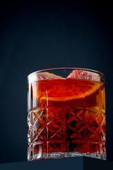 Alcoholic orange cocktail with oranges and ice in a glass. Concrete background. Aperol spritz