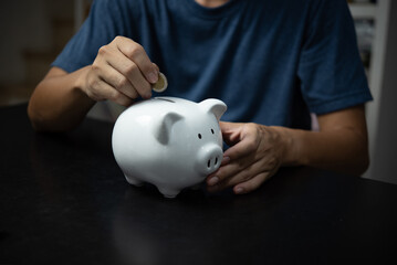 Man holding coin in white piggy bank, investment, finance, banking, savings and retirement concept