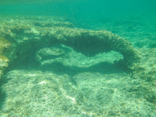 Arco de piedra natural formado bajo el agua, fotografía submarina. Fondo marino de la costa del mar Jónico, costa de Pizzo en Italia.