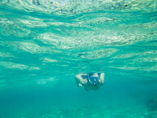 Chica joven practicando snorkel en aguas cristalinas. Fondo marino de la costa del mar Jónico, costa de Pizzo en Italia. - obrazy, fototapety, plakaty