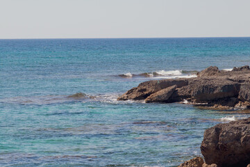 Litoral rocoso con un mar en calma un soleado día de verano. Vista marina de la costa del mar Jónico, costa de Pizzo en Italia.