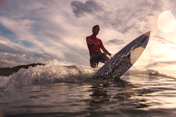 Surfer at sunset, Sumbawa, Indonesia