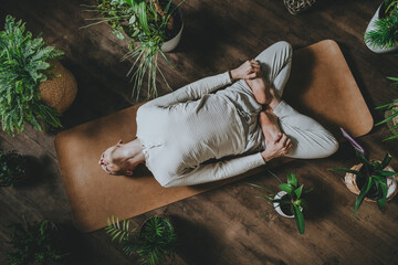 Top view of young meditating man with long blond hair laying on cork mat