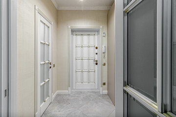 Fototapeta premium The interior of a stylish house in light colors with white doors with glass.