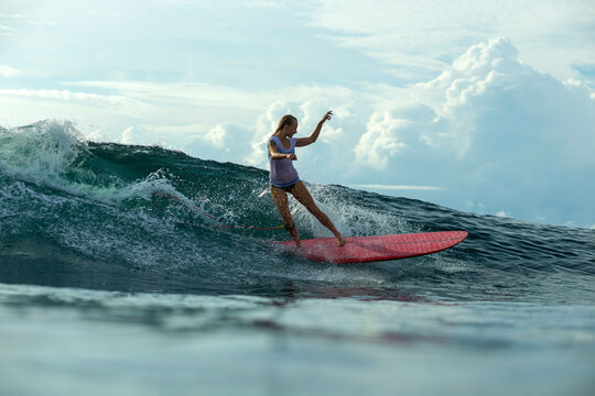 Surfer girl keeps her balance as she rides a wave.