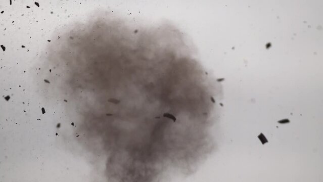 Slow motion close-up clip of a clay pigeon that shatters into pieces in mid-air after getting shot