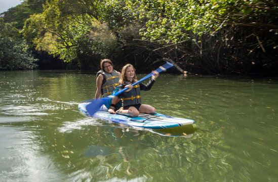 Mother and daughter on paddle board, Waimea river, Kauai