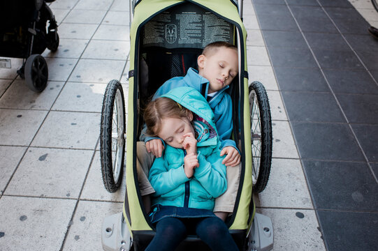 boy and girl sleeping in a stroller