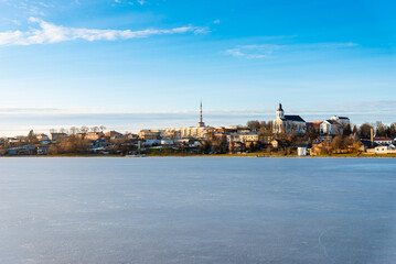 Fototapeta na wymiar Telsiai town,ice lake in Lithuania. Nice view winter of colorful houses on coast of frozen Lake.Nice winter evening.Copy space.