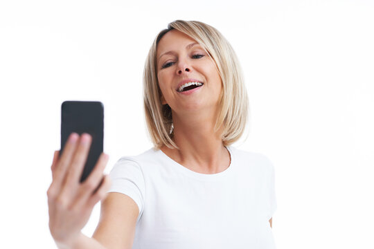 Picture of blonde woman over back isolated background with mobile phone
