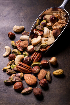 in the foreground, a food scoop with an assortment of shelled nuts